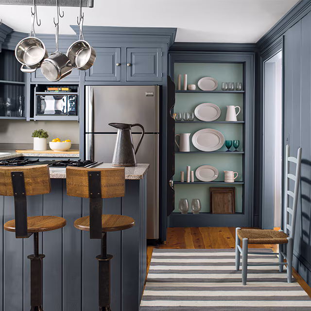 Slate blue-gray painted kitchen paneling and a built-in shelf with a contrasting green painted interior